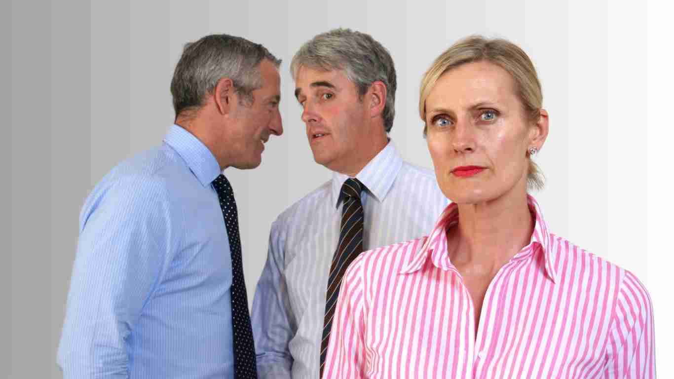 Two men in the background gossiping about a woman in the foreground