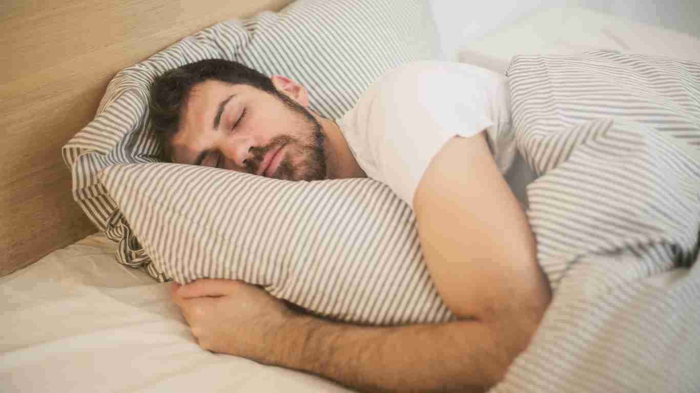 A man fast asleep in a comfortable bed