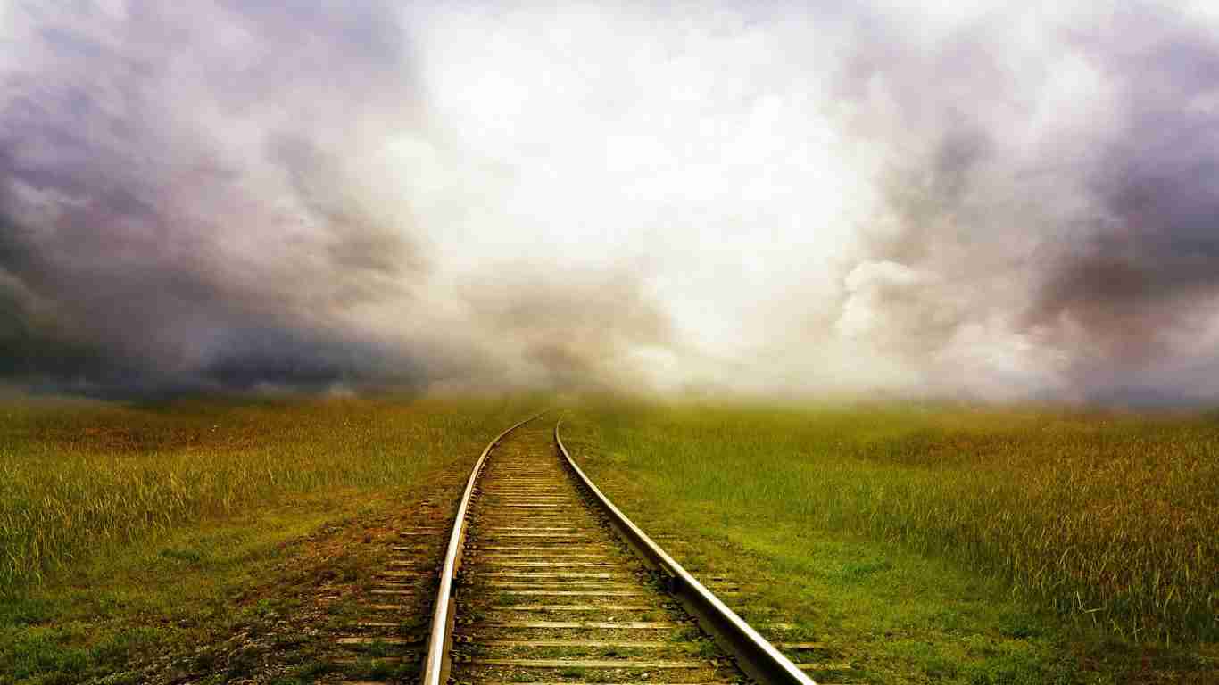 Train tracks leading into a dense fog, symbolizing destiny