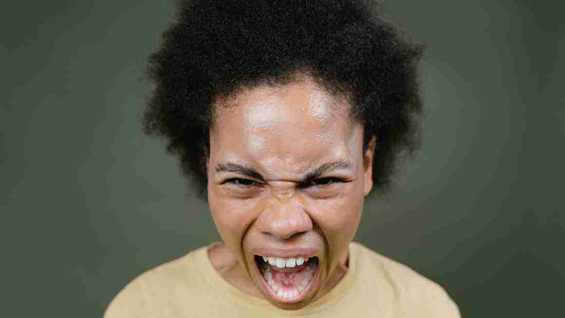 A furious woman screaming at the camera