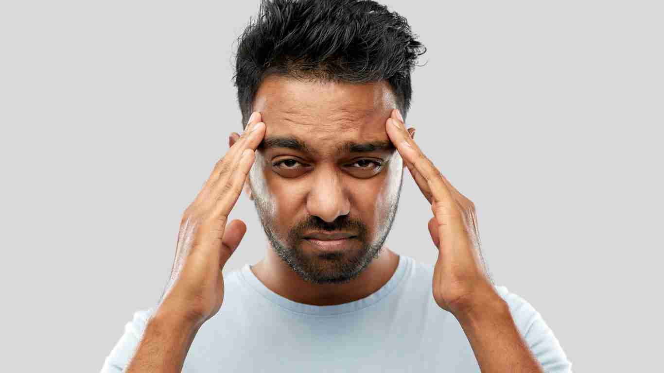 A very confused man rubbing his forehead