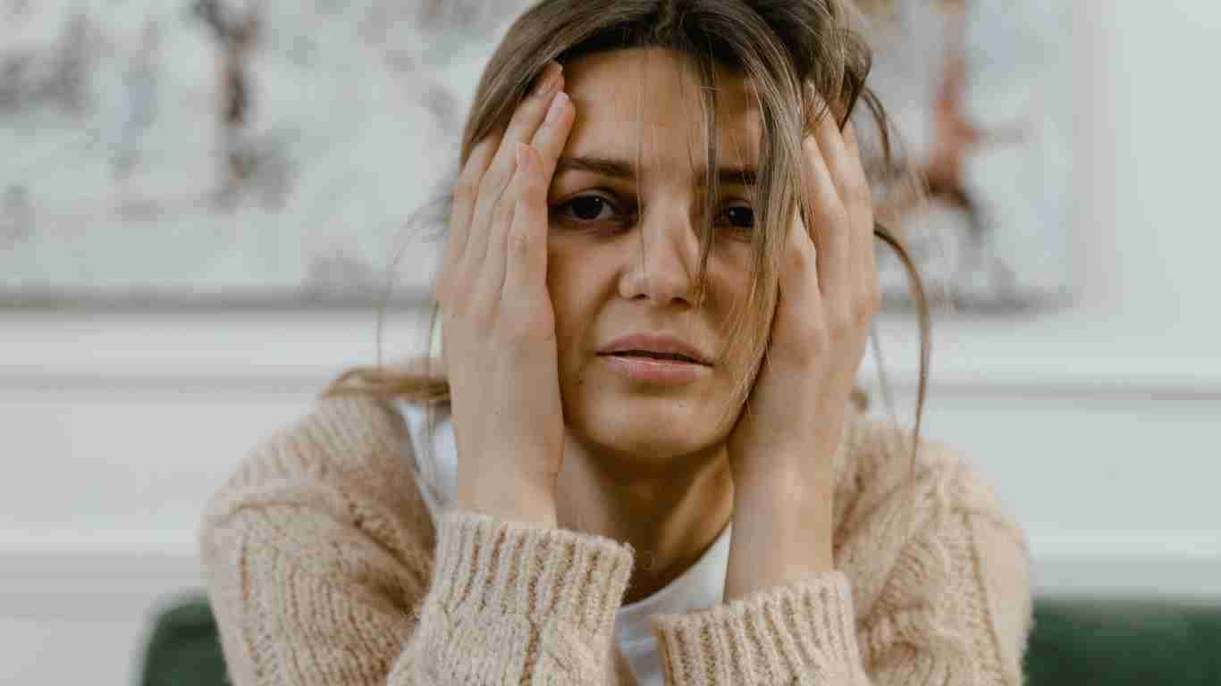 A distraught woman clasping her head