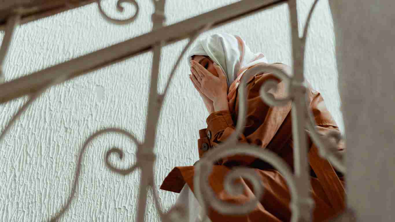 A distraught woman crying in a stairwell