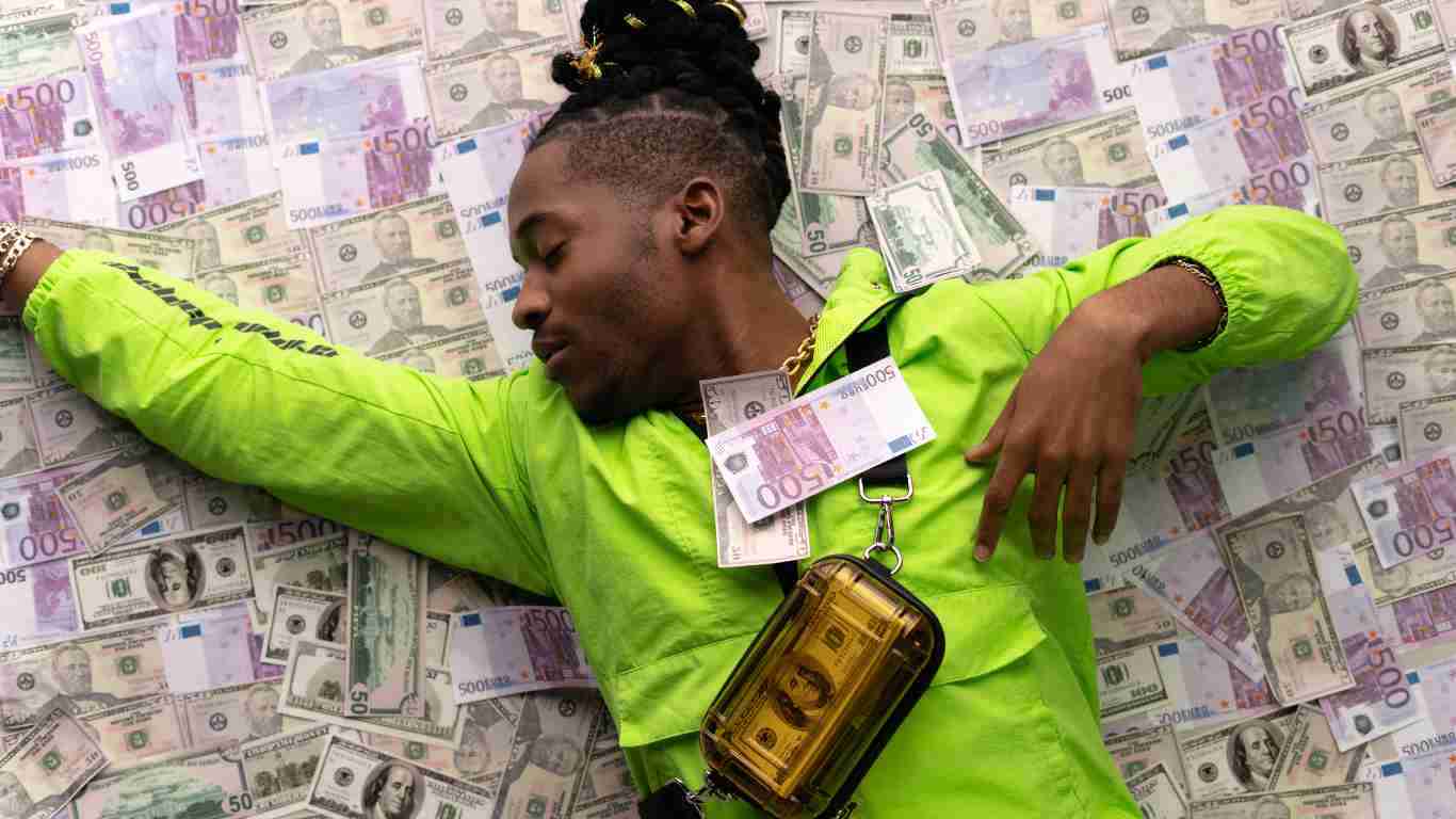 A man lying down on a massive pile of money