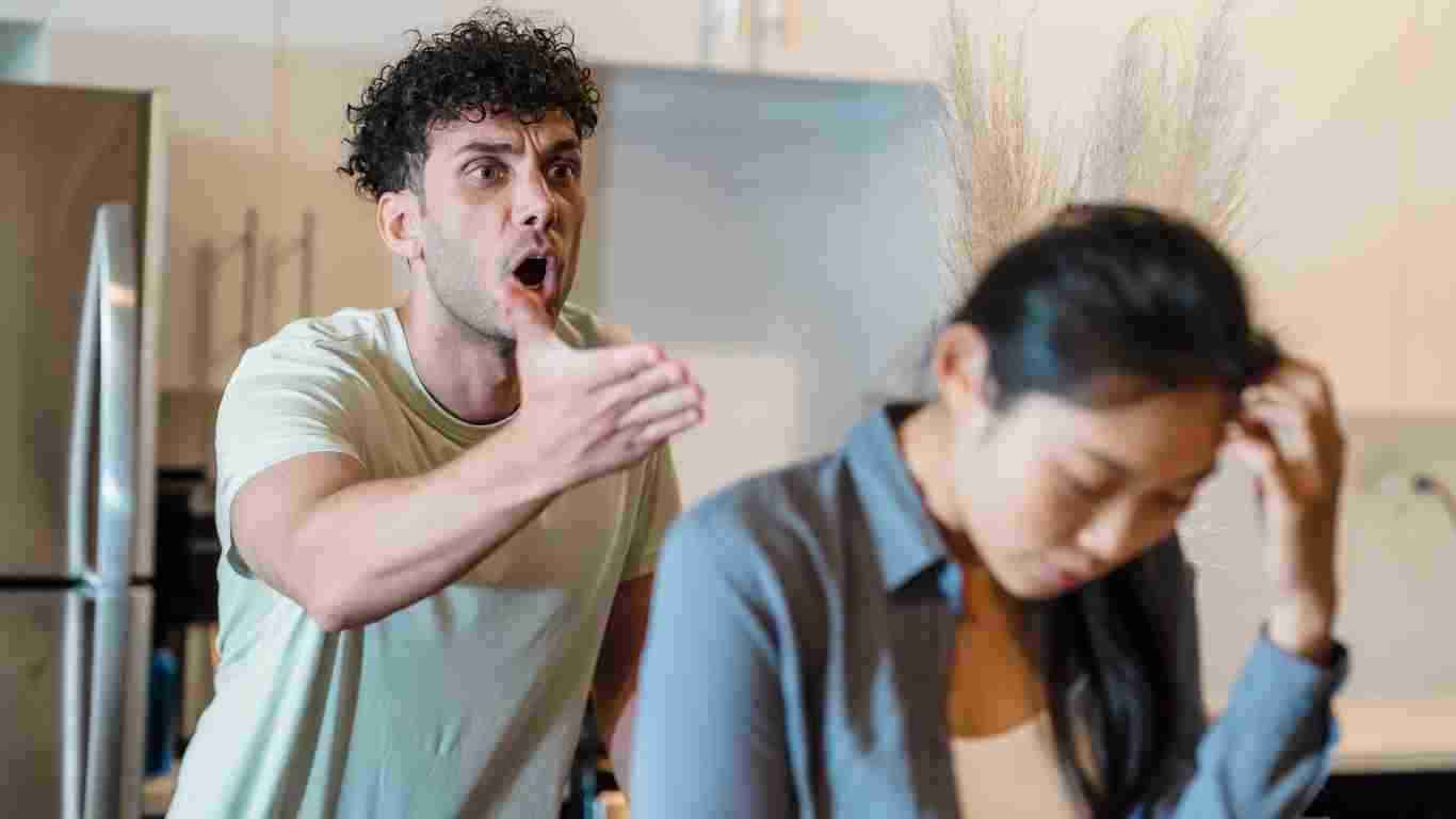 A man insulting his partner, who looks totally distraught