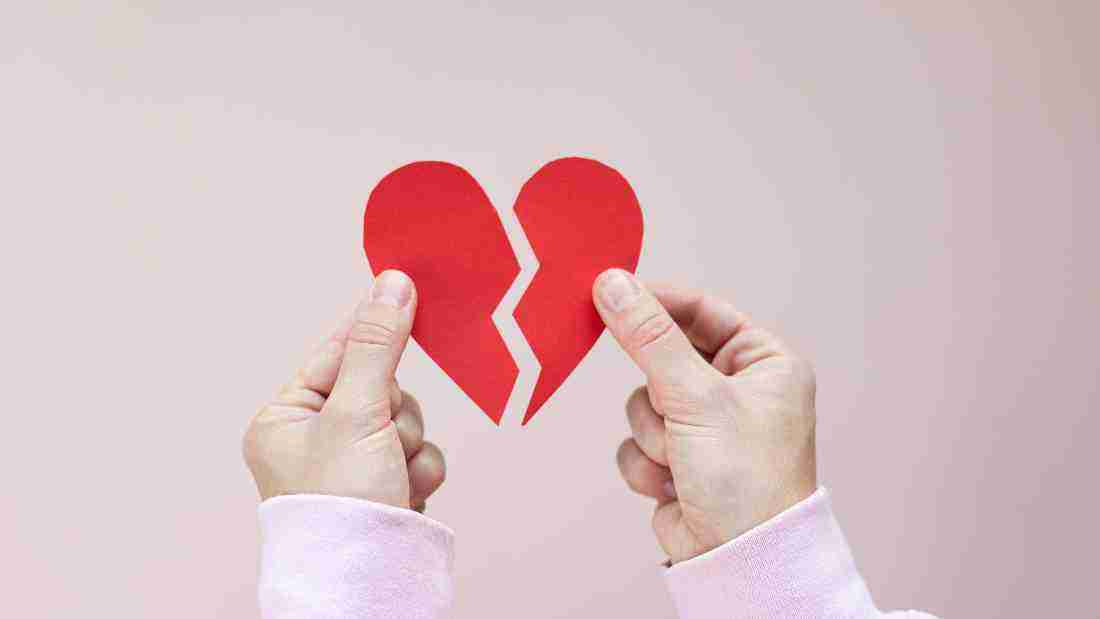 A woman holding a broken heart