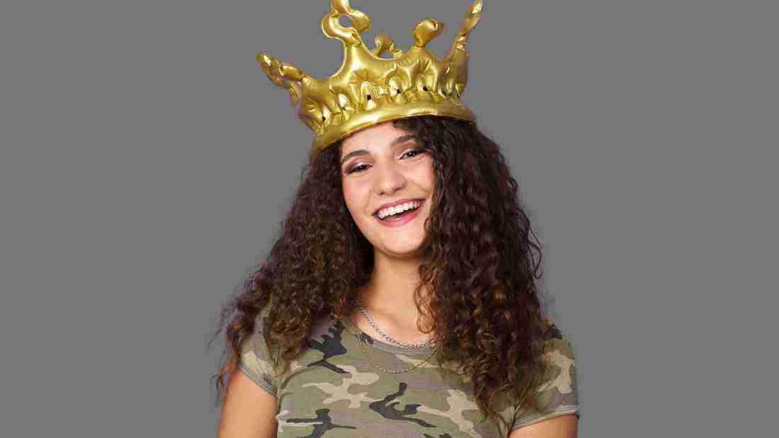 A young woman wearing a massive golden crown