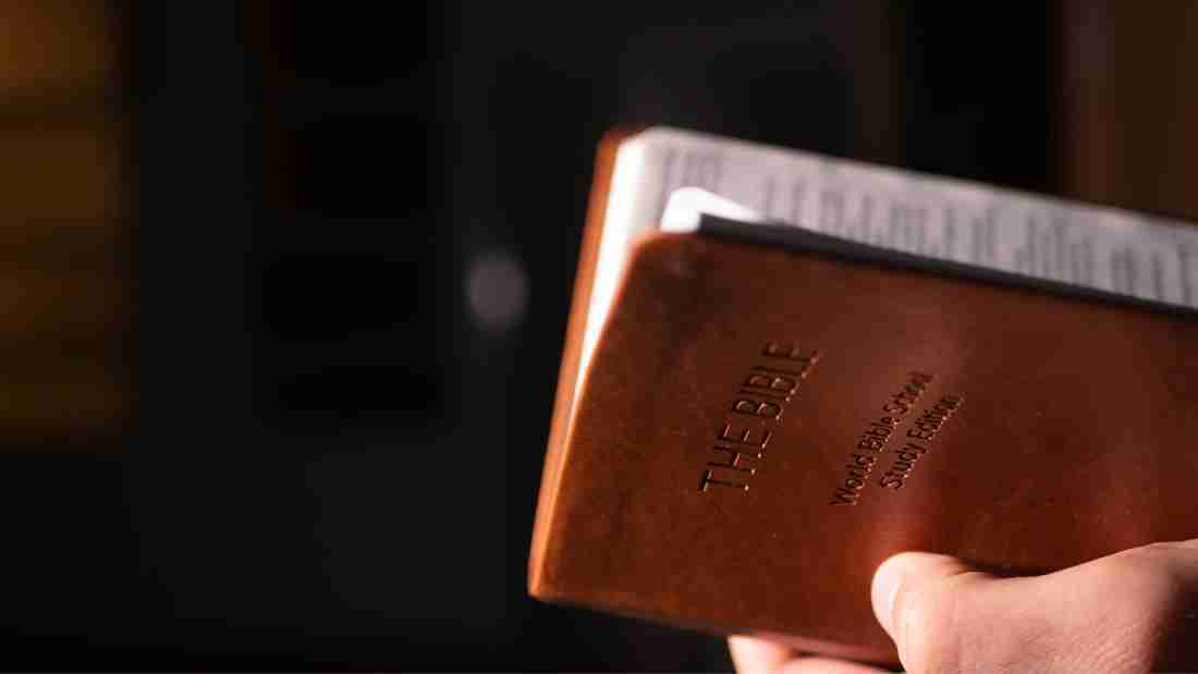 A man holding a leather-bound bible