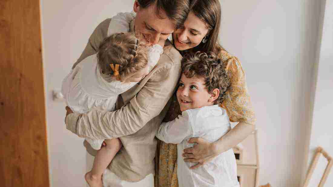 Mother, father, son and daughter hugging