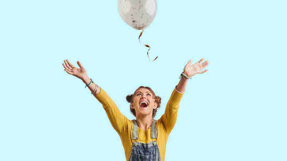 A woman beaming as she chases a balloon