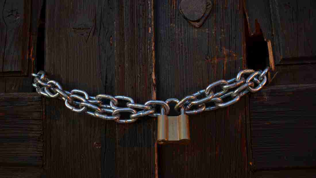A door locked with a strong chain and padlock
