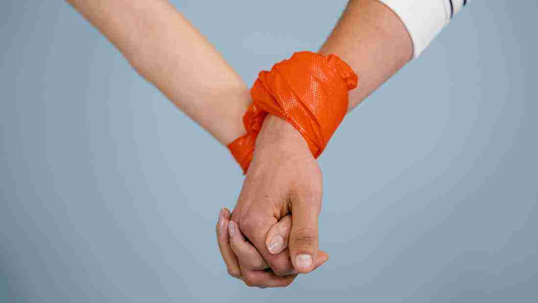 A couple tied together with orange plastic