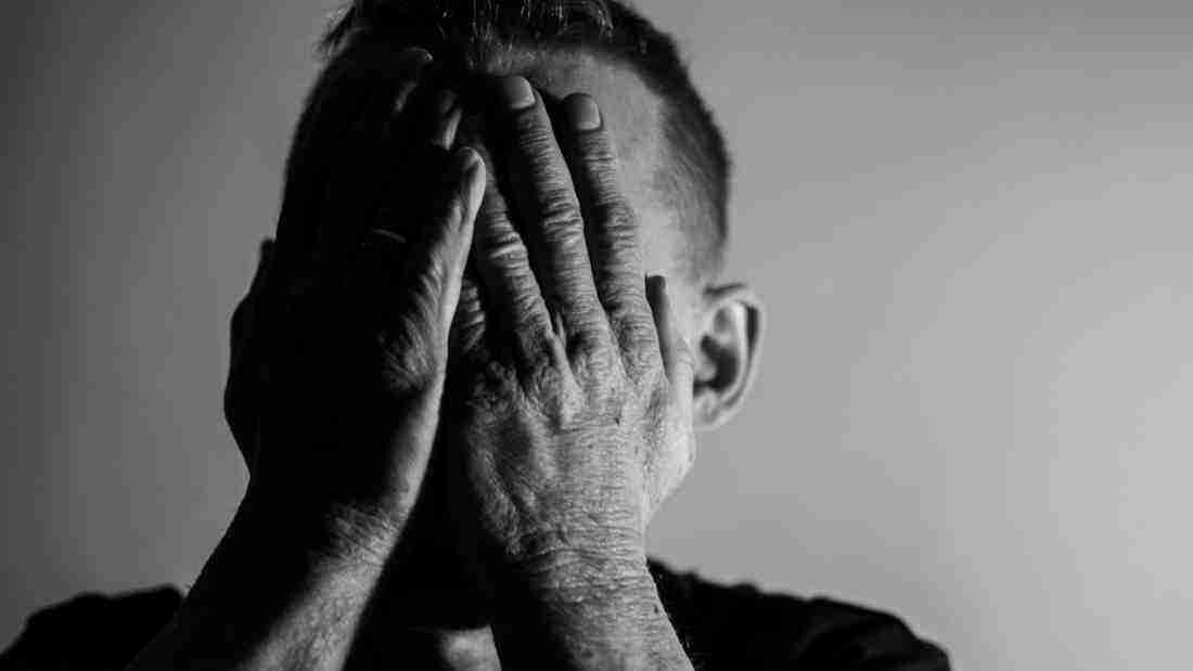 A man covering his face in despair