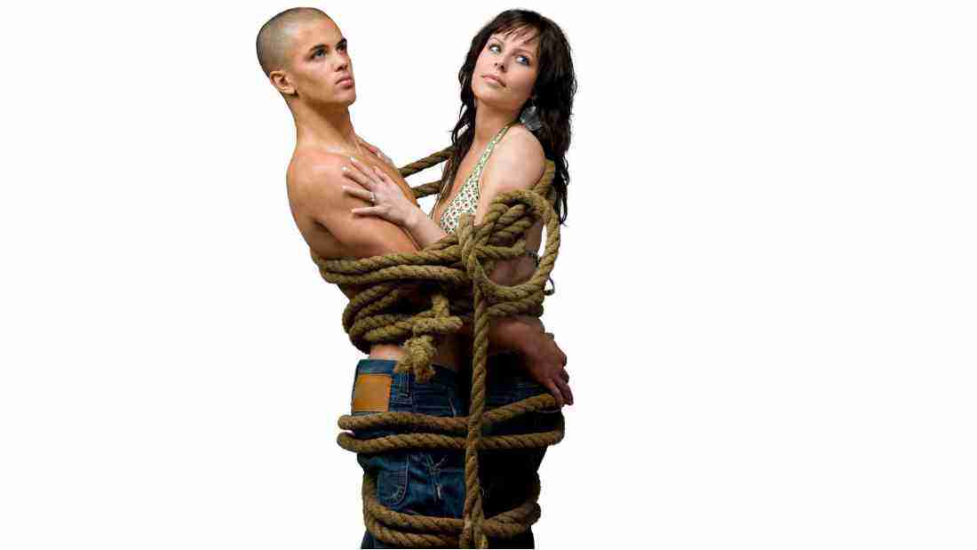 A couple tied together with ropes wound tight around them