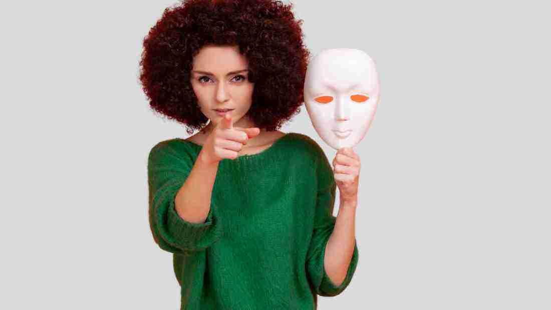 A woman exposing her true self by taking off her mask