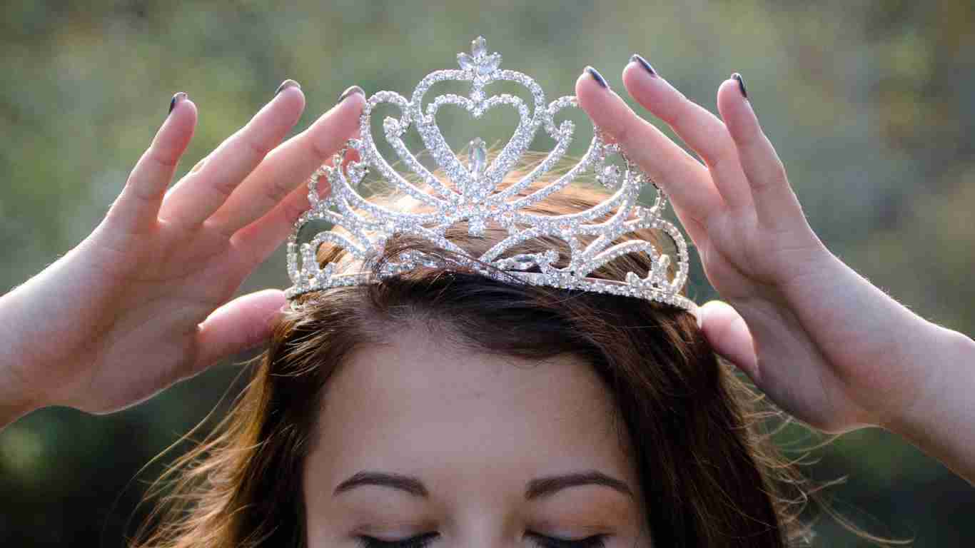 A young woman putting on a tiara