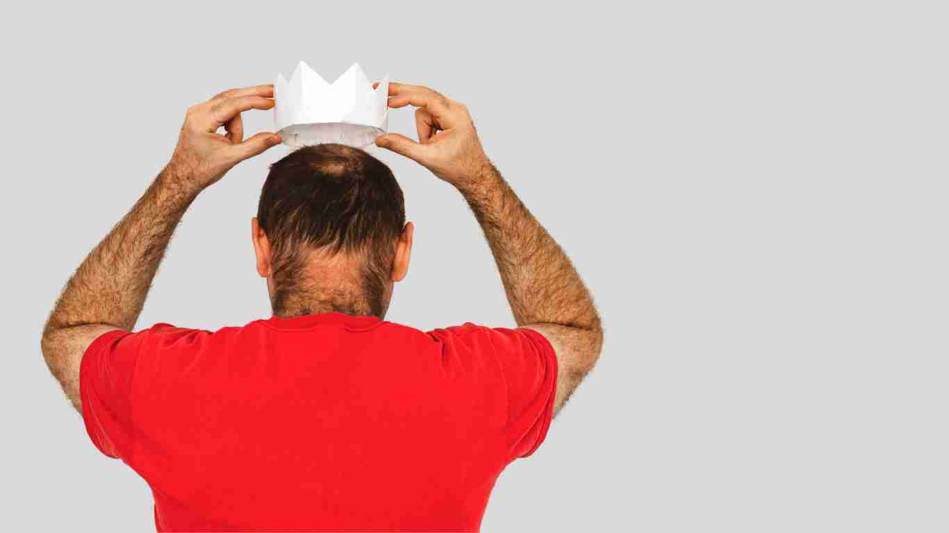 A man putting a white crown on his head