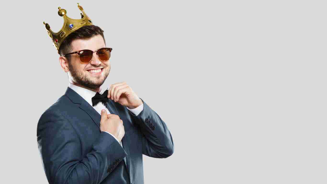 A man wearing a golden crown and dark sunglasses