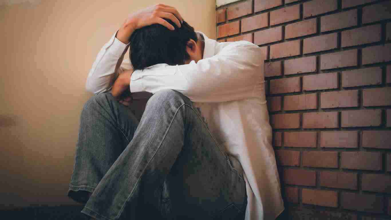 A young man who appears to be overwhelmed with sadness