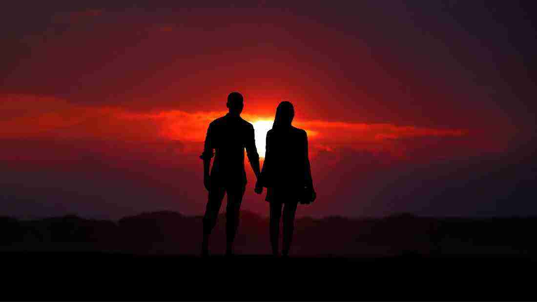Silhouettes of a couple watching a spectacular sunset