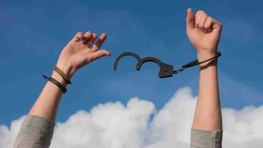 A woman breaking free from chains