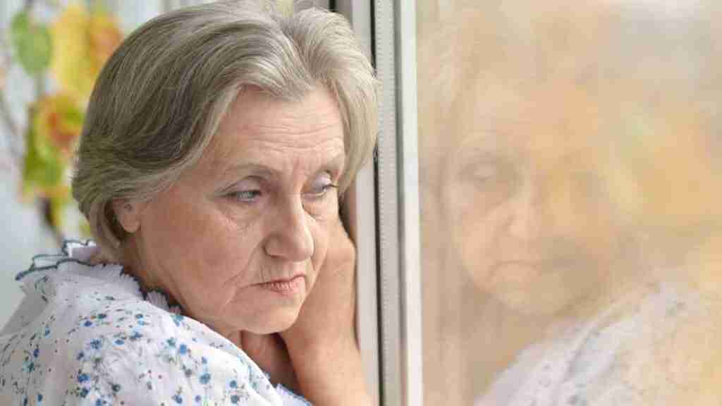 A sad grandmother gazing out of the window.