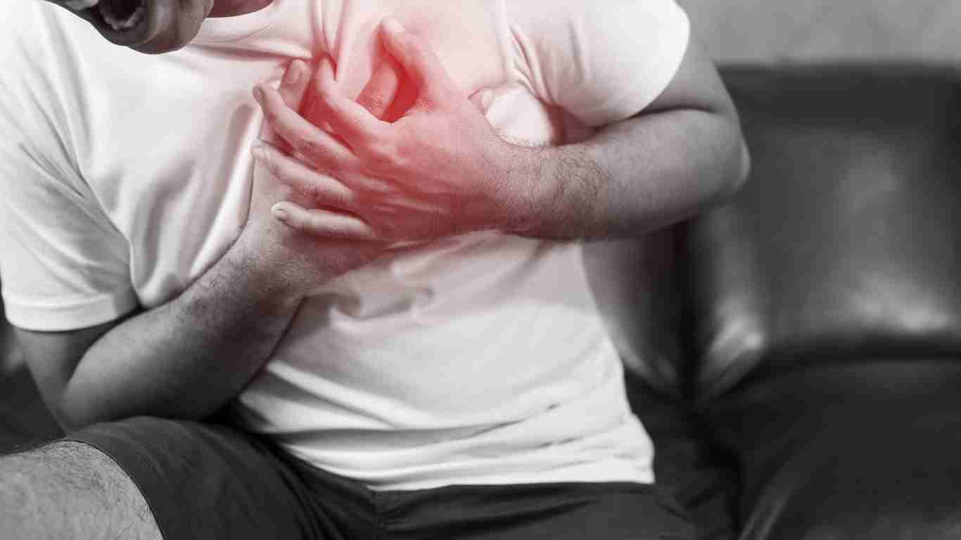 A man clutching his chest as he has a heart attack
