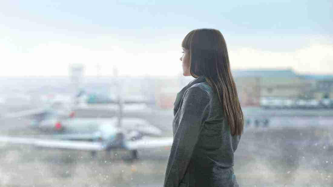 A sad woman looking out at the rain