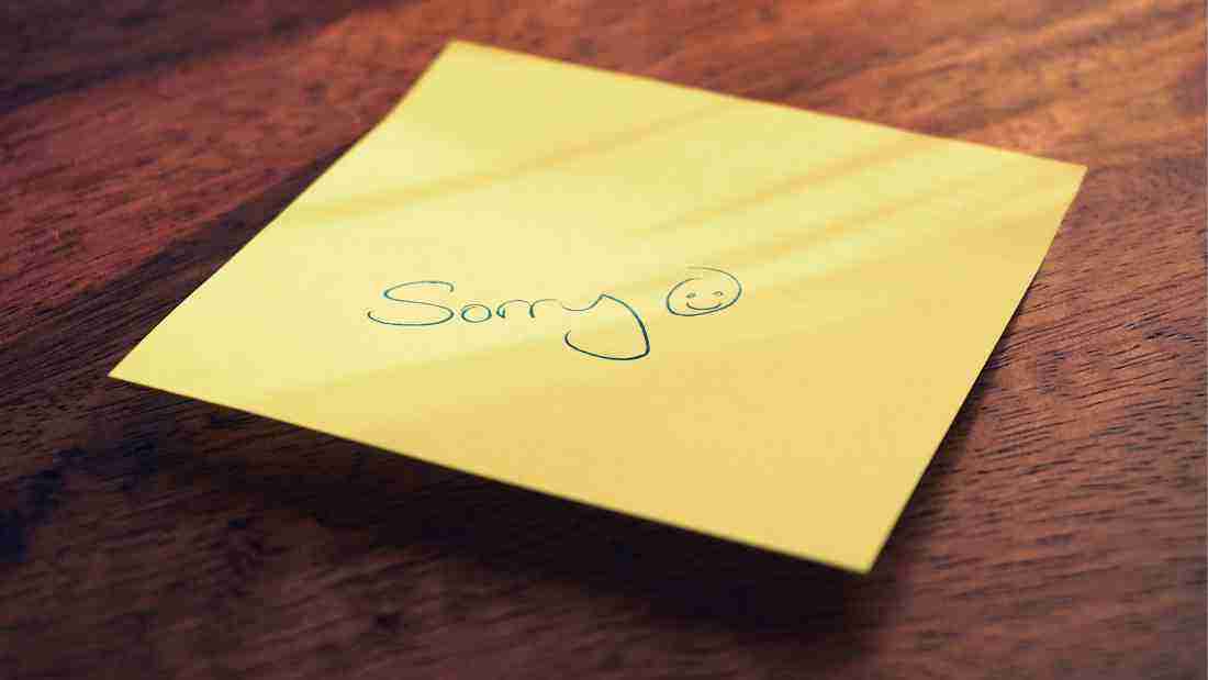 Sorry written on a post-it note, with a smiley that indicates that the person is not really sorry