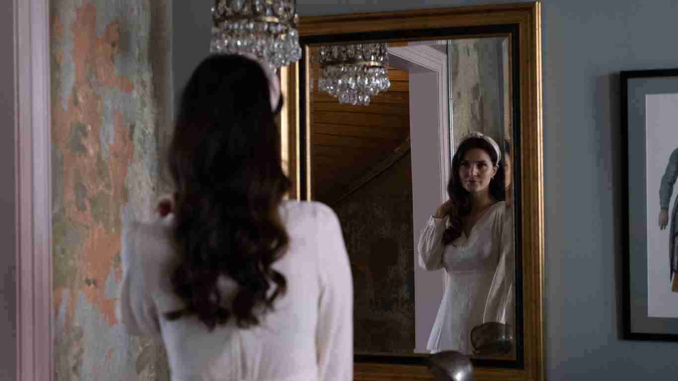 Woman admiring herself in an opulent mirror