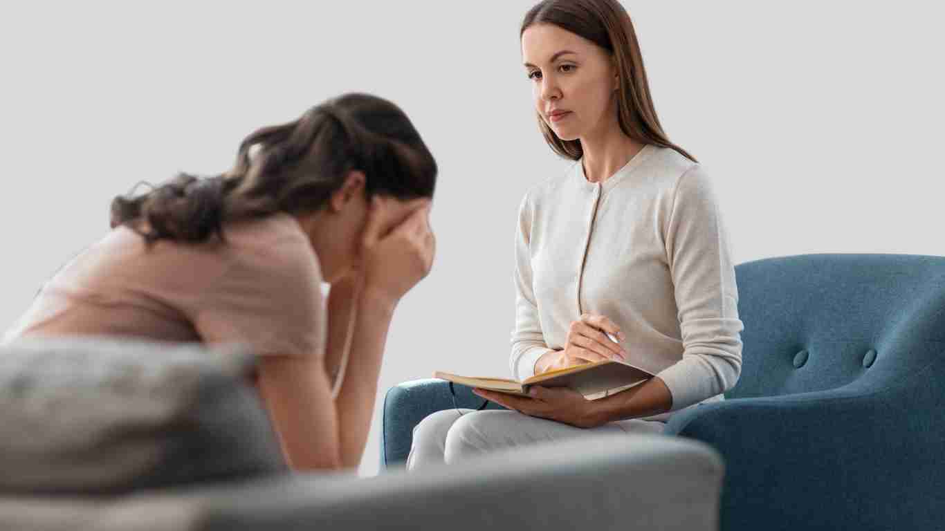 A young woman crying as she talks to her therapist