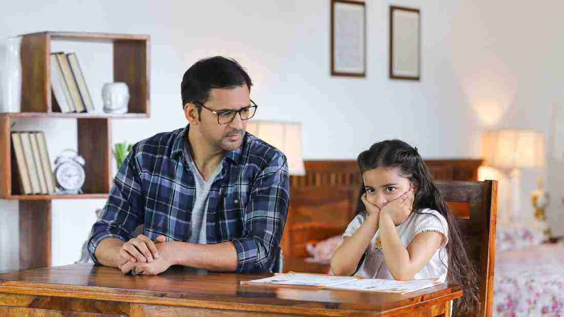 An angry father glaring at his young daughter