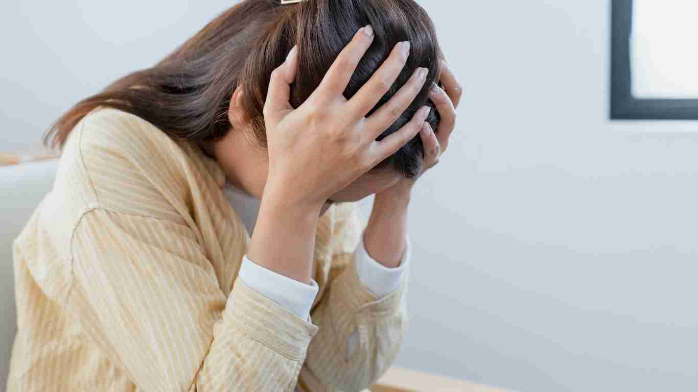 A woman holding her head in despair