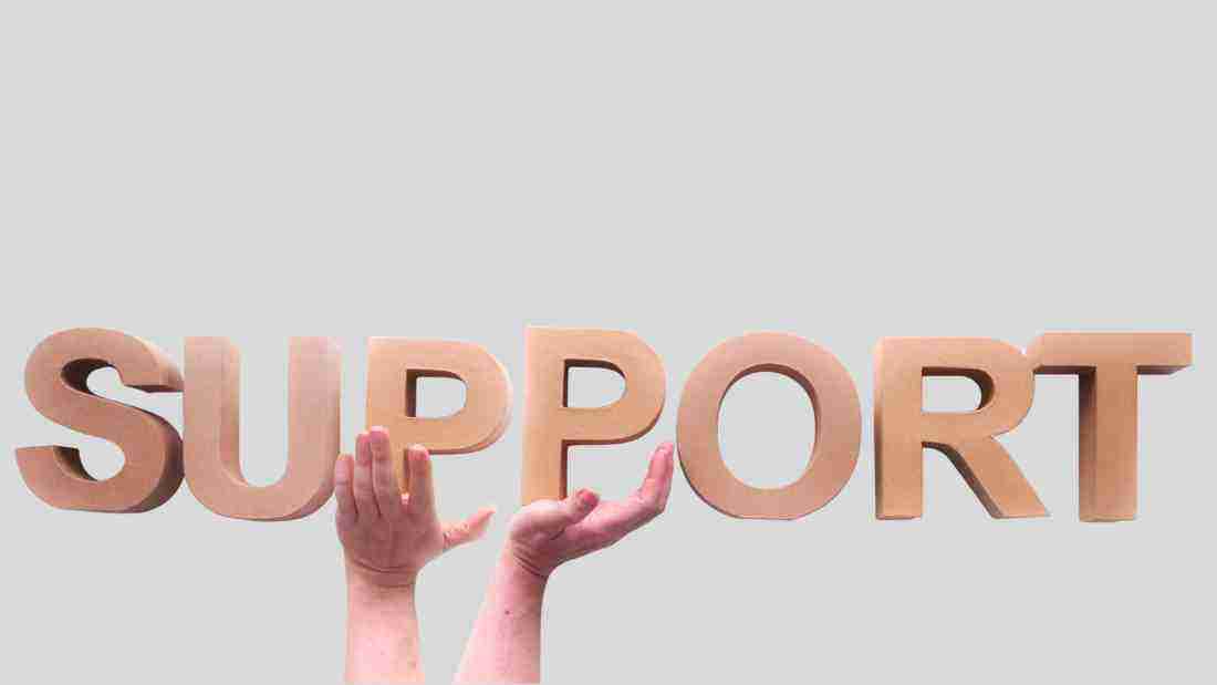 Hands holding up the word SUPPORT