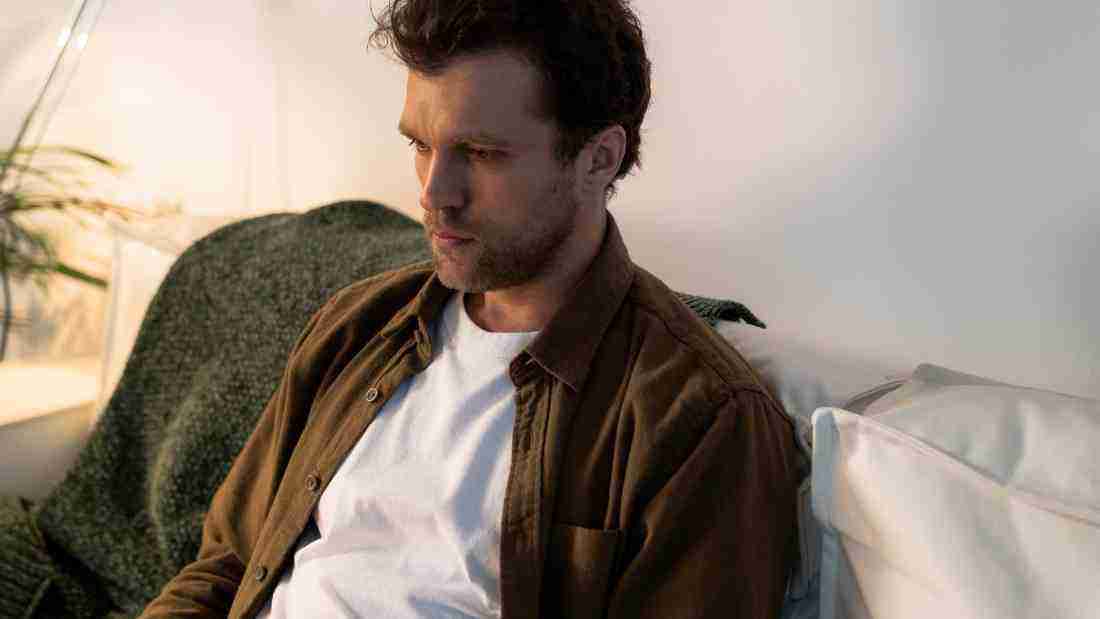 A depressed man sitting on a sofa