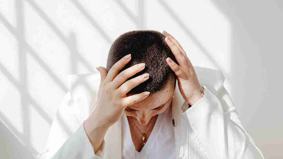 A woman holding her head in her hands