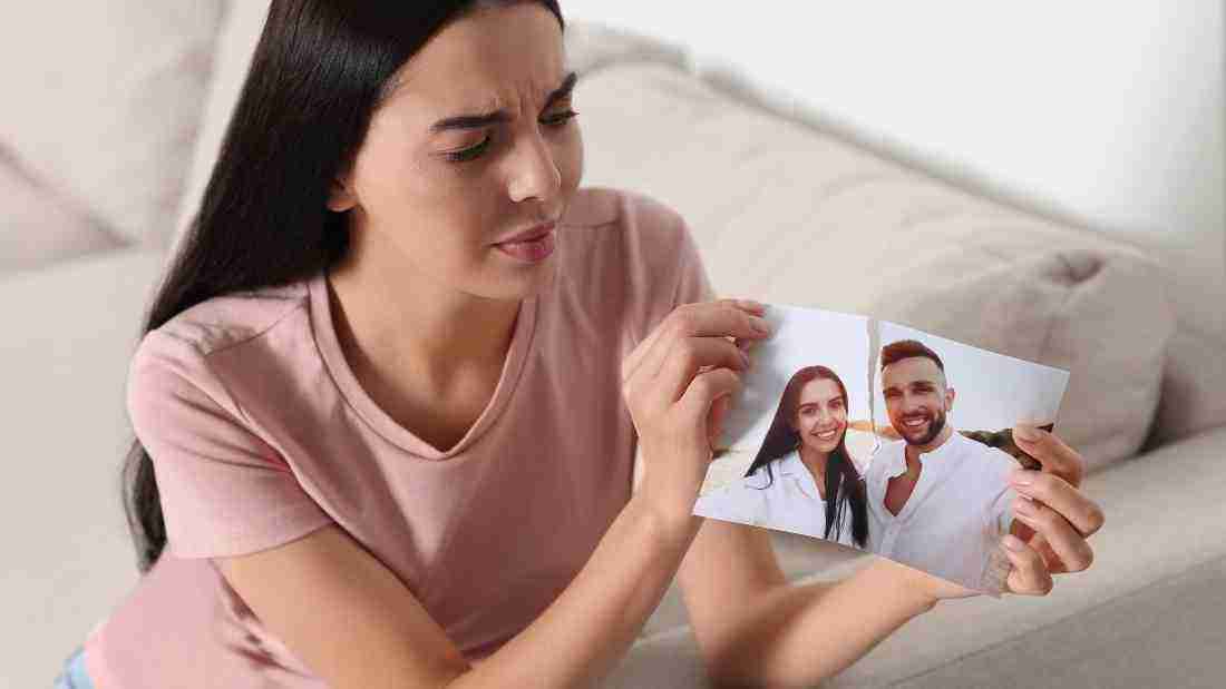 A woman tearing up a photo after a breakup
