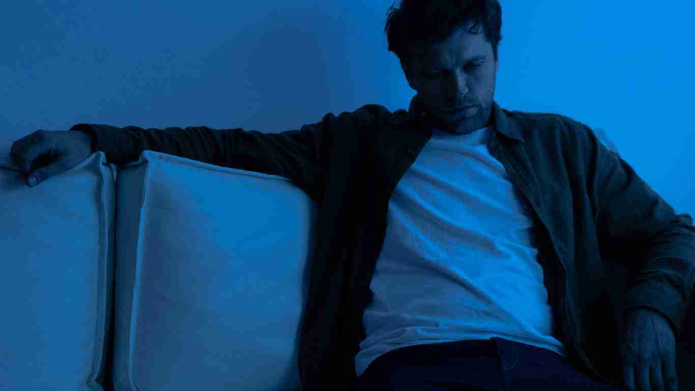 A depressed man sitting in the dark