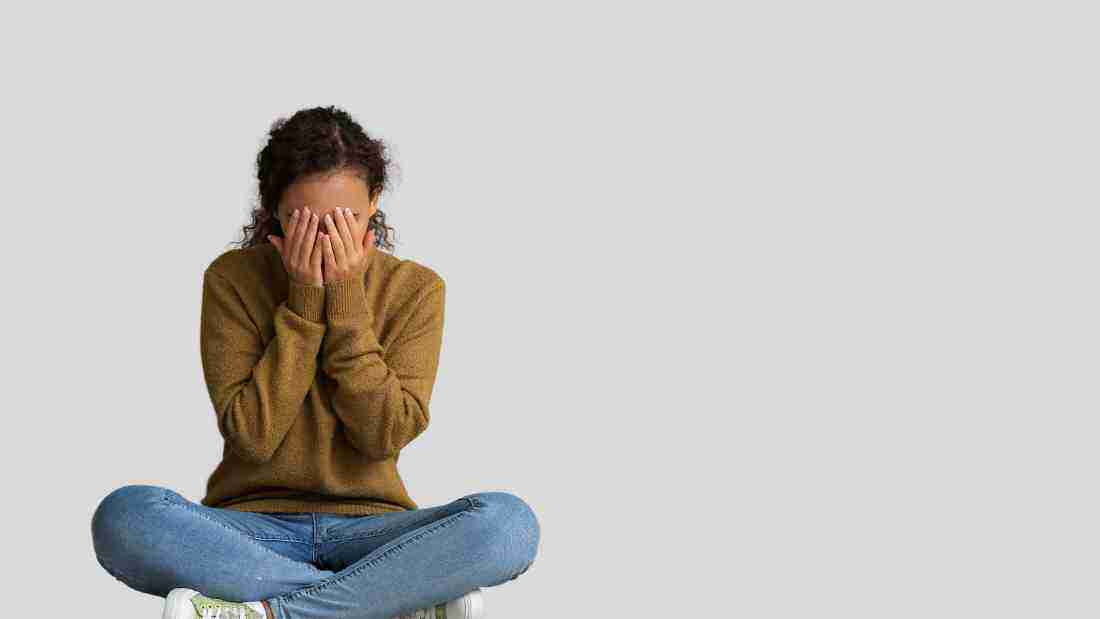 A woman hiding her face in humiliation