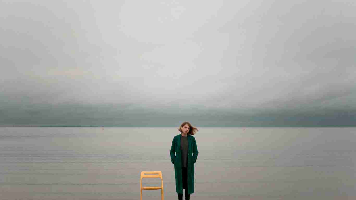 A woman standing alone in an isolated and desolate spot