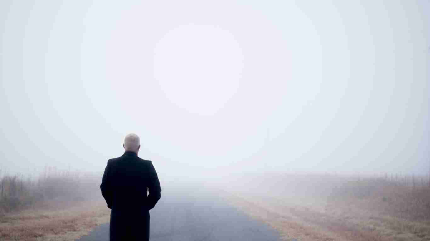 A man walking alone in the thick fog