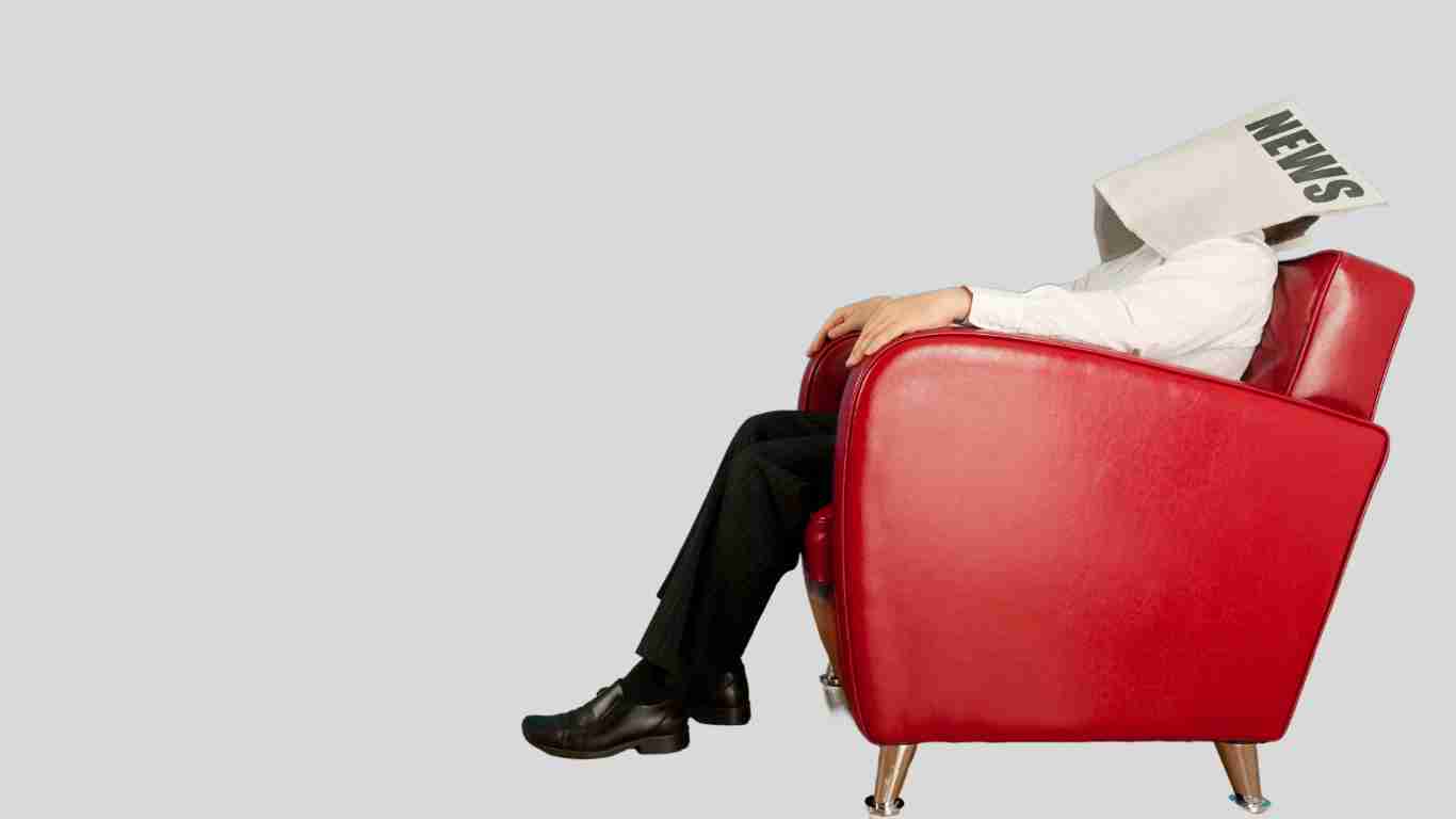 A man fast asleep on a red armchair