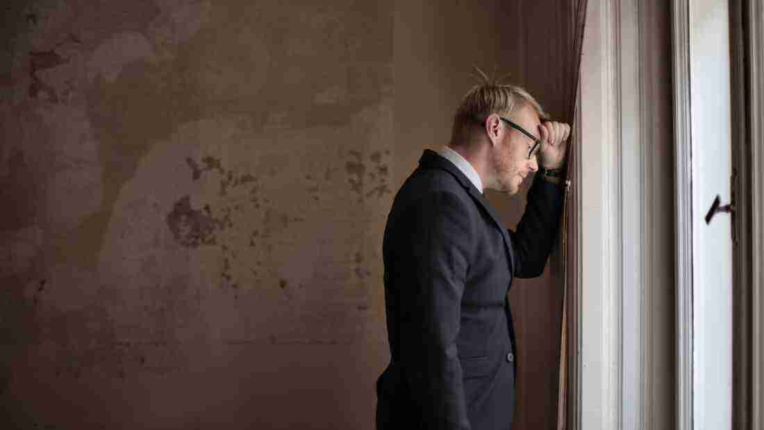 Man banging his head against the wall