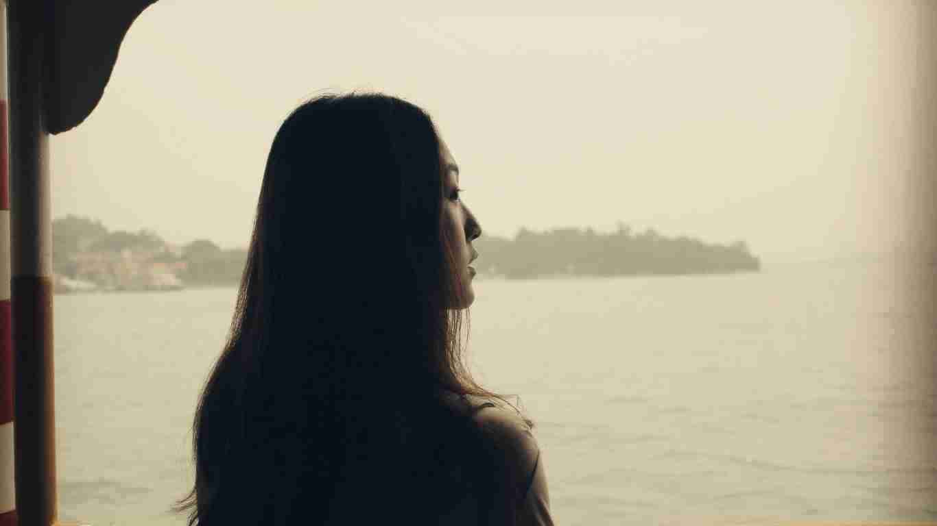 Sad woman looking out of a balcony