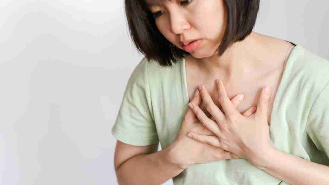 A woman clutching her chest in pain
