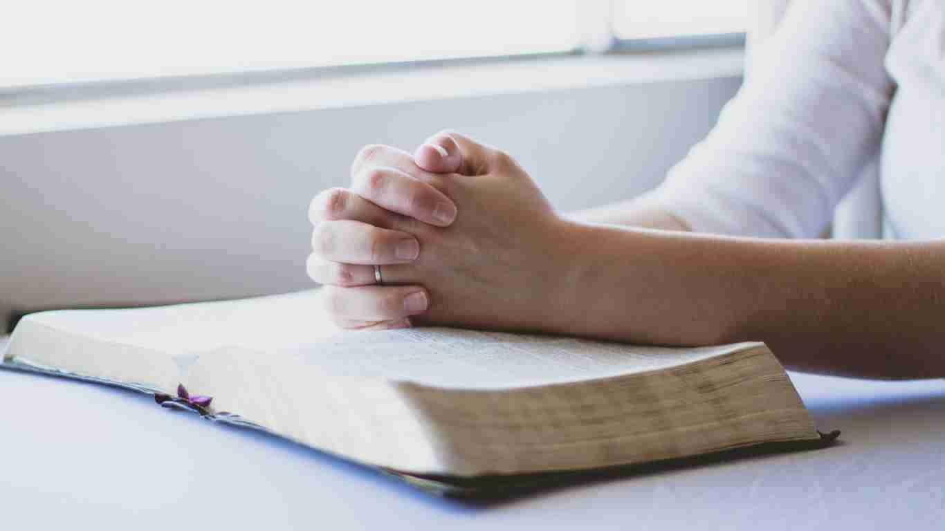 A woman praying over the Bible