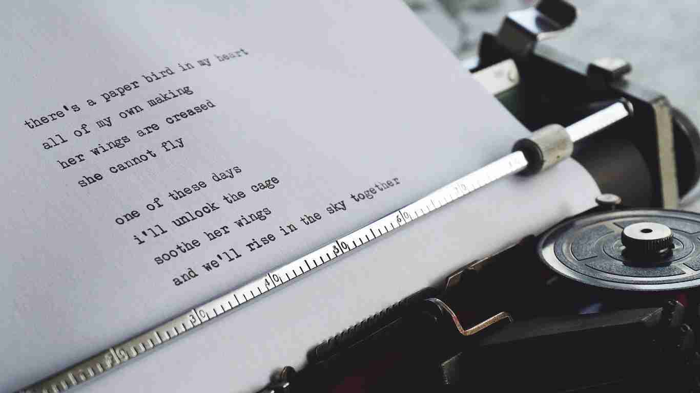 A man trying a poetry on an old-fashioned typrwriter