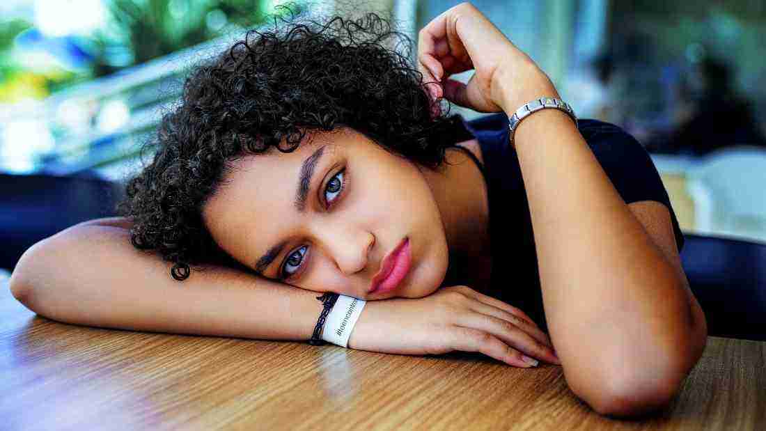 Depressed young woman with her head on the table