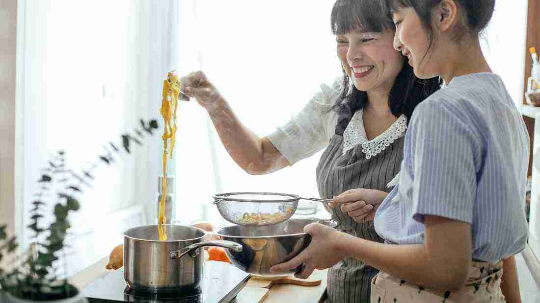 a mother cooking with her teenage daughter
