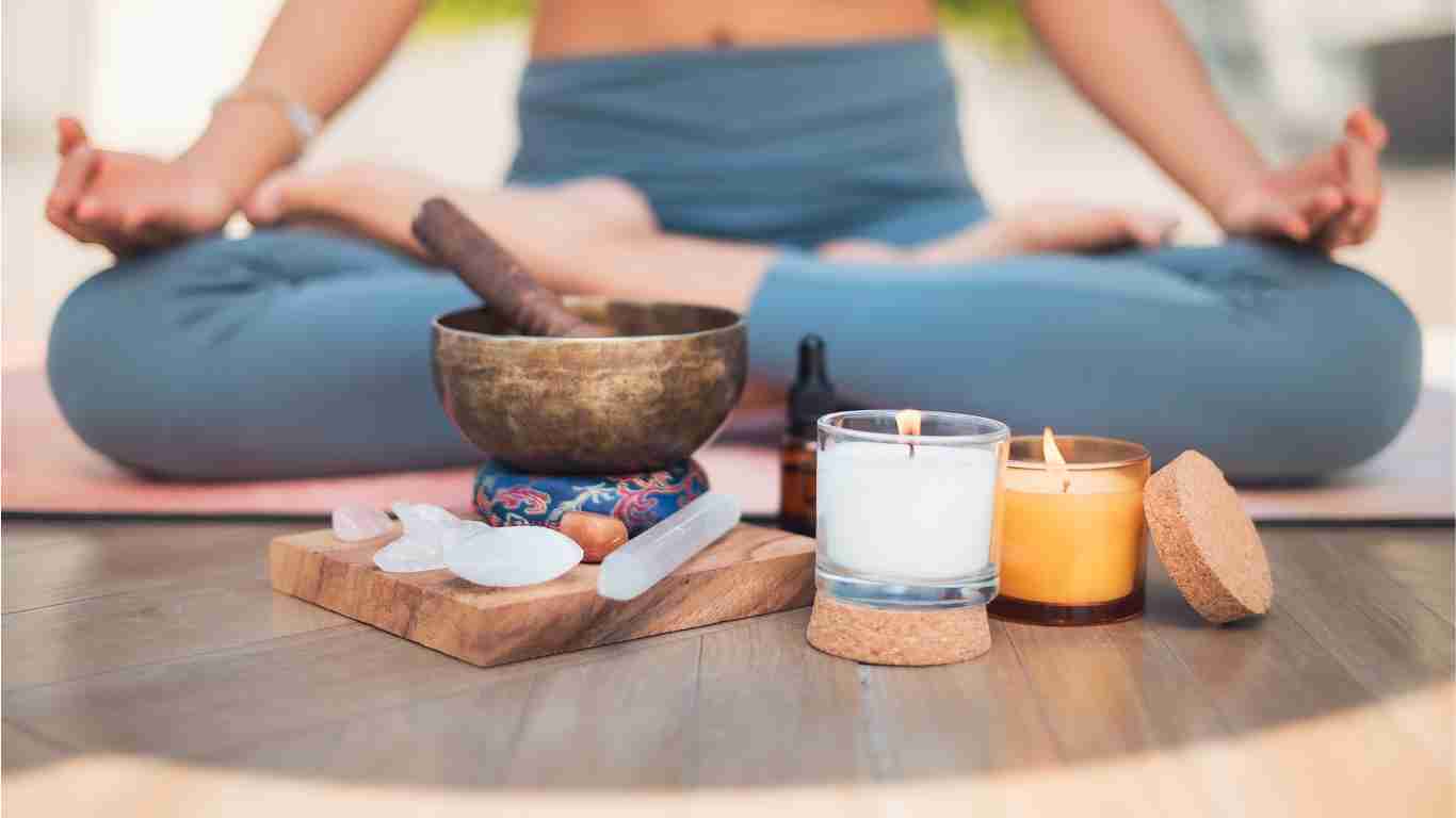 A woman meditating with candles and incense